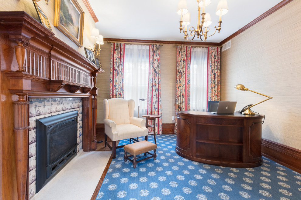 Cette image montre un bureau traditionnel avec un mur beige, un sol en bois brun, une cheminée standard, un manteau de cheminée en carrelage, un bureau indépendant et du papier peint.