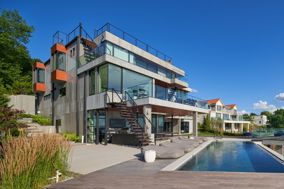Exemple d'une grande façade de maison moderne en béton à deux étages et plus avec un toit plat et un toit végétal.