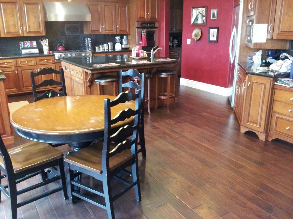 Photo of a traditional eat-in kitchen in San Francisco with with island and brown floor.