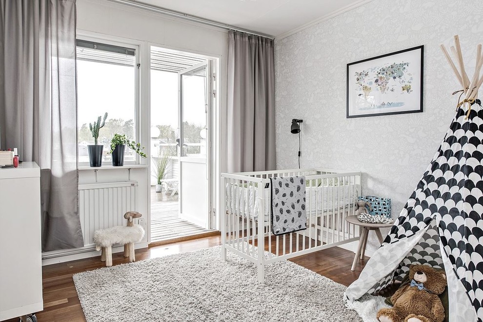This is an example of a scandinavian gender-neutral nursery in Gothenburg with grey walls, dark hardwood floors and brown floor.
