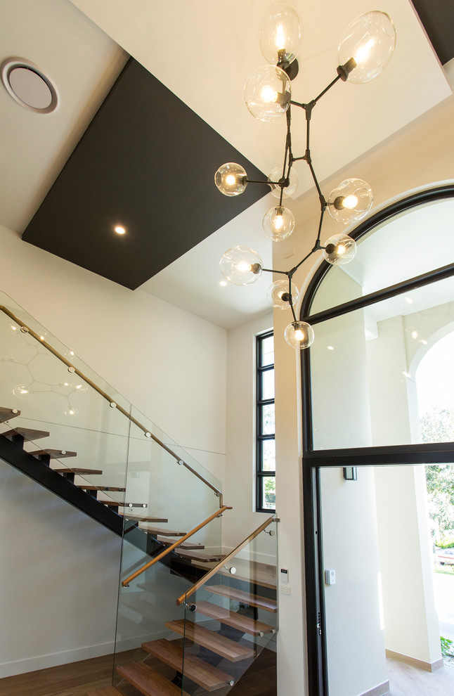 Photo of a contemporary foyer in Melbourne with beige walls, light hardwood floors and a single front door.