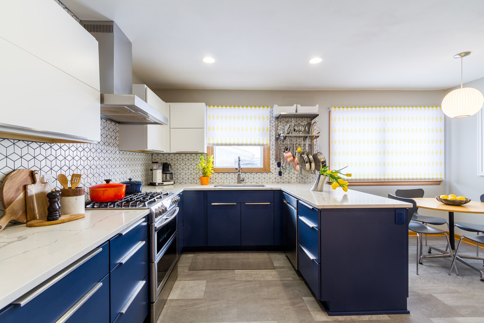 This is an example of a mid-sized midcentury u-shaped eat-in kitchen in Milwaukee with an undermount sink, flat-panel cabinets, blue cabinets, quartz benchtops, ceramic splashback, stainless steel appliances, a peninsula, grey floor, white benchtop, multi-coloured splashback and concrete floors.