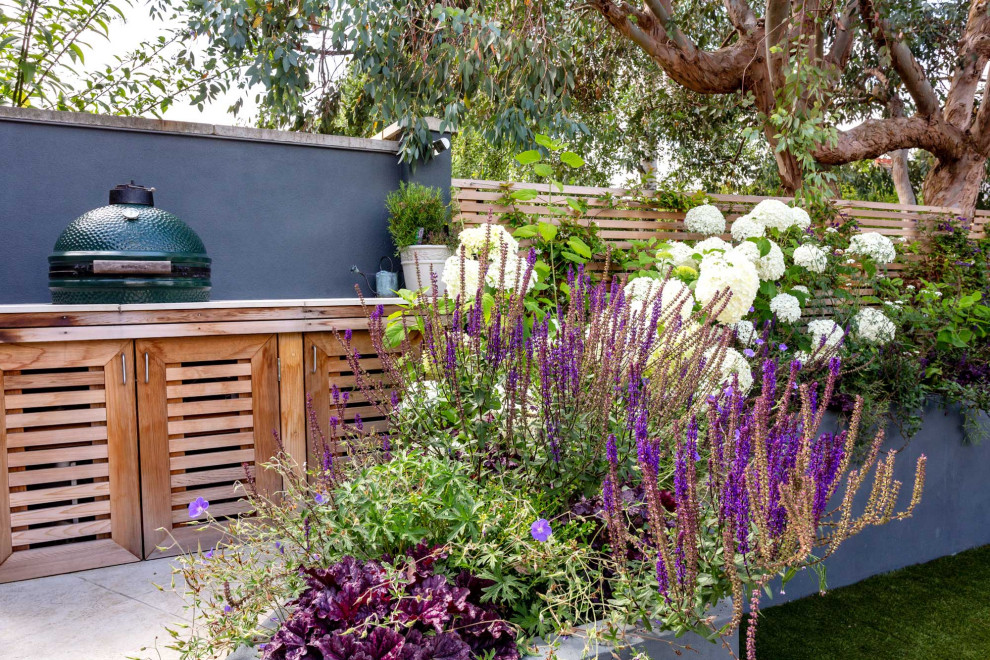 Photo of a small contemporary backyard garden in London with with raised garden bed and natural stone pavers.