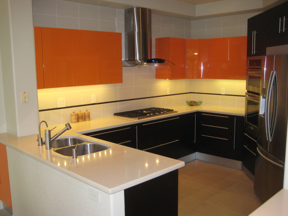 This is an example of a mid-sized modern l-shaped eat-in kitchen in San Diego with a double-bowl sink, flat-panel cabinets, orange cabinets, quartz benchtops, white splashback, ceramic splashback, stainless steel appliances, light hardwood floors and no island.
