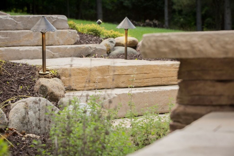 This is an example of a mid-sized transitional full sun backyard stone landscaping in Chicago.