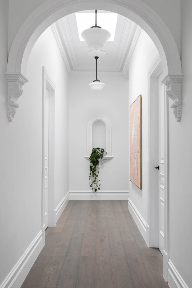 Inspiration for a mid-sized traditional hallway in Melbourne with white walls, dark hardwood floors and brown floor.
