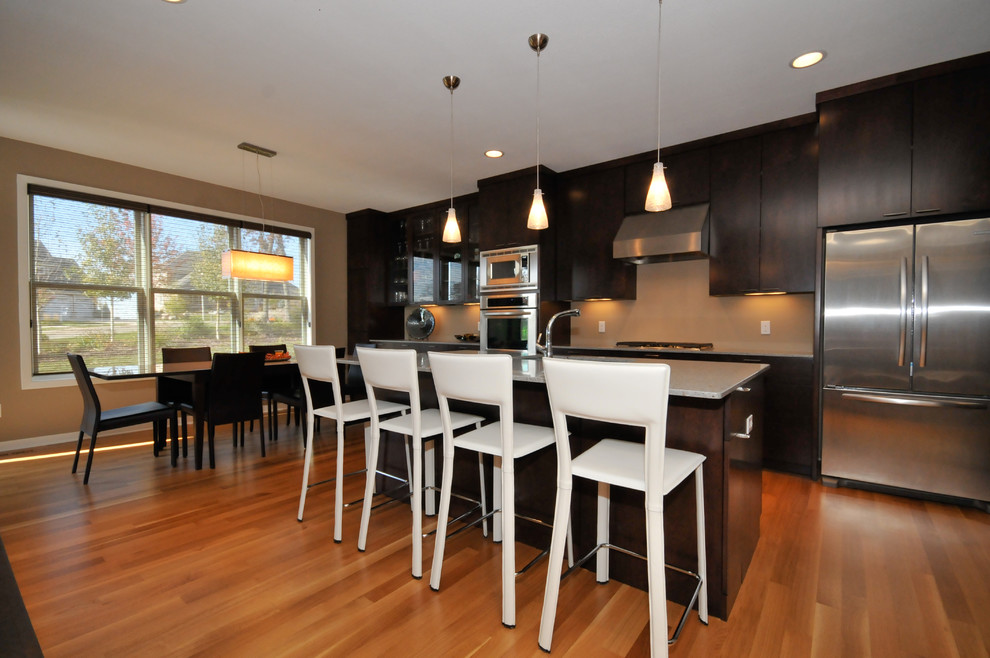 This is an example of a contemporary eat-in kitchen in Other with flat-panel cabinets and dark wood cabinets.