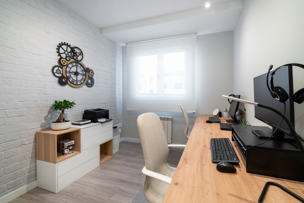 Ispirazione per un ufficio scandinavo di medie dimensioni con pareti grigie, pavimento in laminato, scrivania autoportante, pavimento grigio e carta da parati