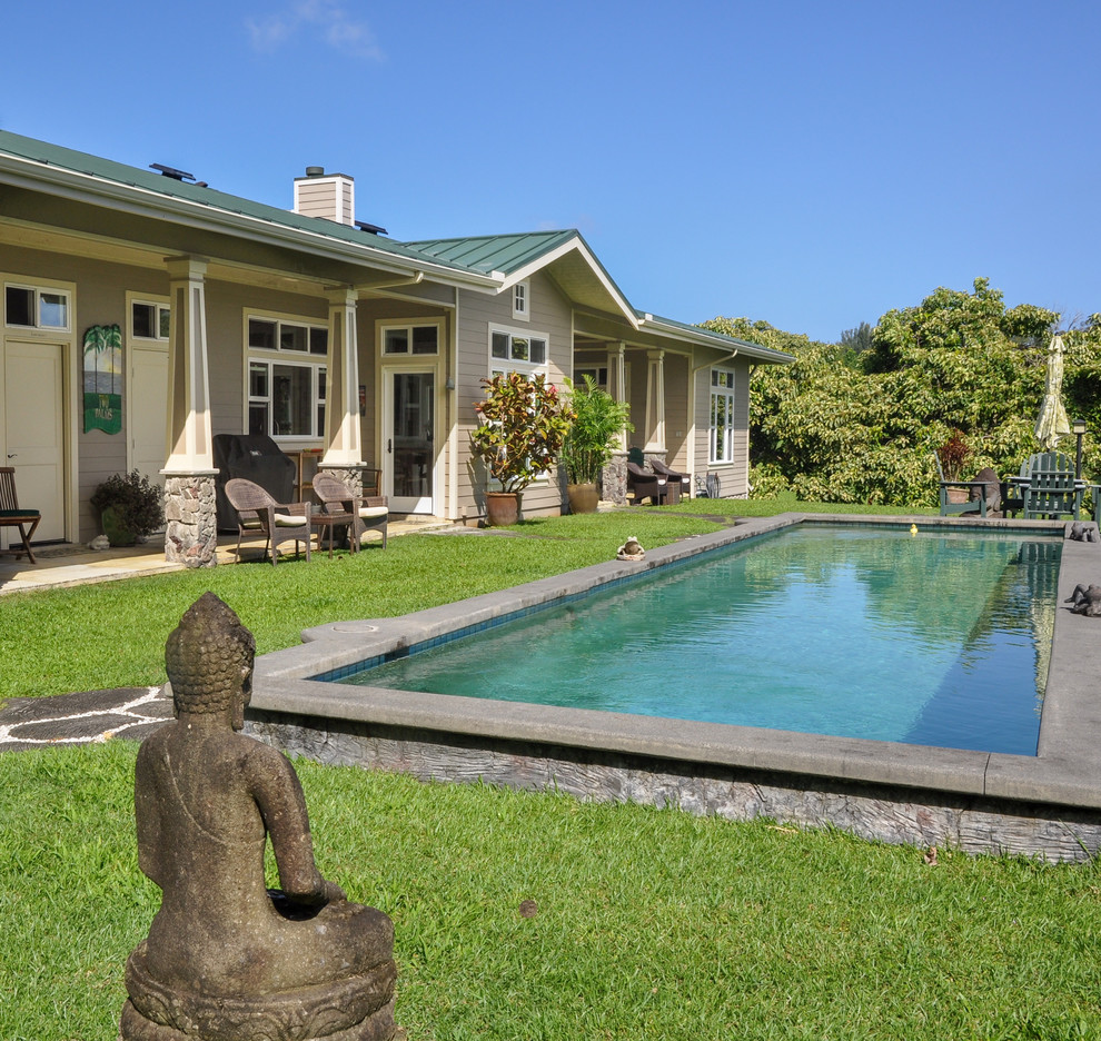 This is an example of a mid-sized contemporary backyard rectangular lap pool in Hawaii with natural stone pavers.