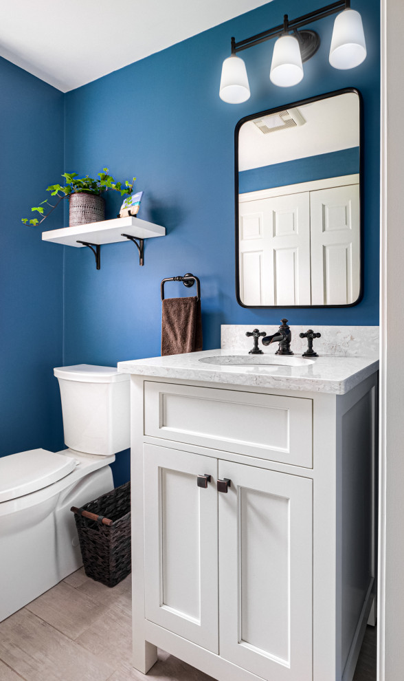 Immagine di una piccola lavanderia multiuso minimal con pareti blu, lavatrice e asciugatrice a colonna e pavimento bianco