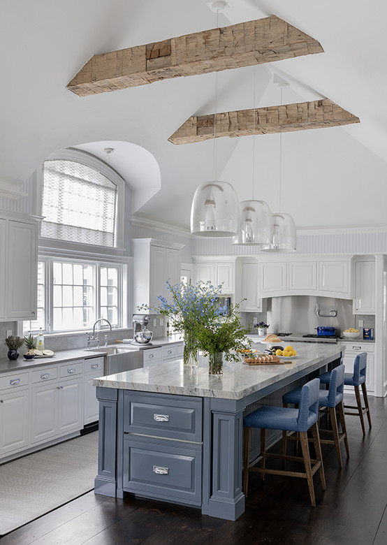 Eat-in kitchen - transitional dark wood floor, brown floor and exposed beam eat-in kitchen idea in Boston with a farmhouse sink, white cabinets, granite countertops, gray backsplash, stainless steel appliances and an island