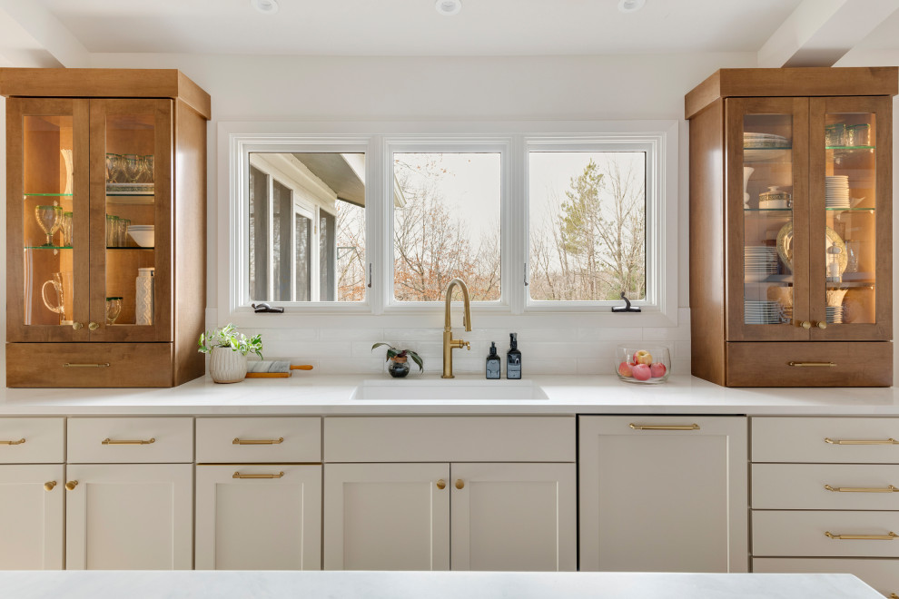 Eat-in kitchen - mid-sized transitional galley medium tone wood floor, brown floor and vaulted ceiling eat-in kitchen idea in Minneapolis with an undermount sink, shaker cabinets, quartz countertops, white backsplash, subway tile backsplash, stainless steel appliances, an island and white countertops