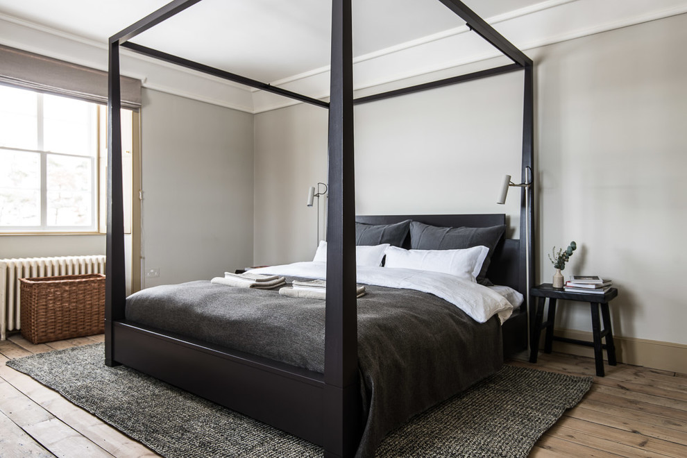 Mid-sized scandinavian master bedroom in Edinburgh with grey walls and medium hardwood floors.