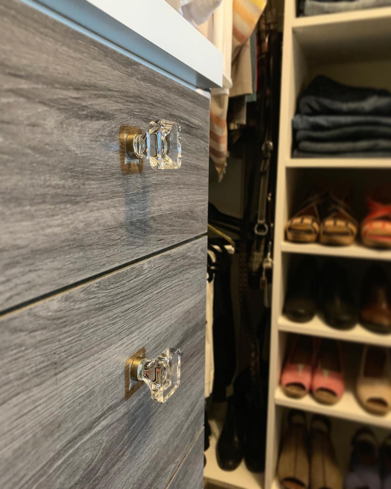 This is an example of a large country gender-neutral walk-in wardrobe in Other with flat-panel cabinets, dark wood cabinets, carpet and grey floor.