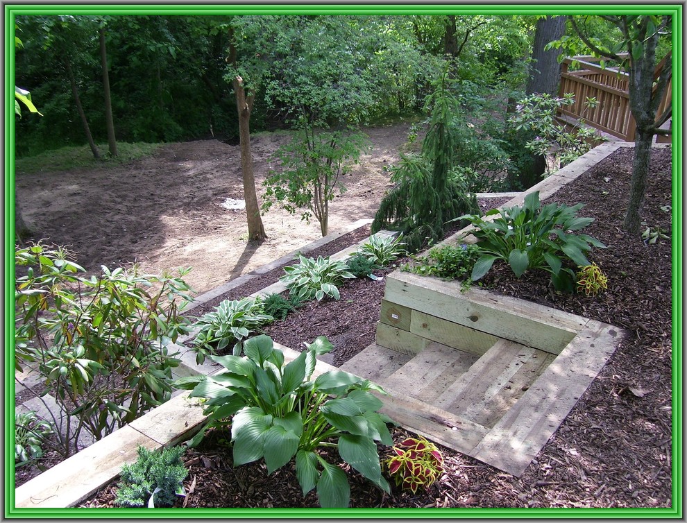 This is an example of a large backyard shaded garden in Detroit with a retaining wall.