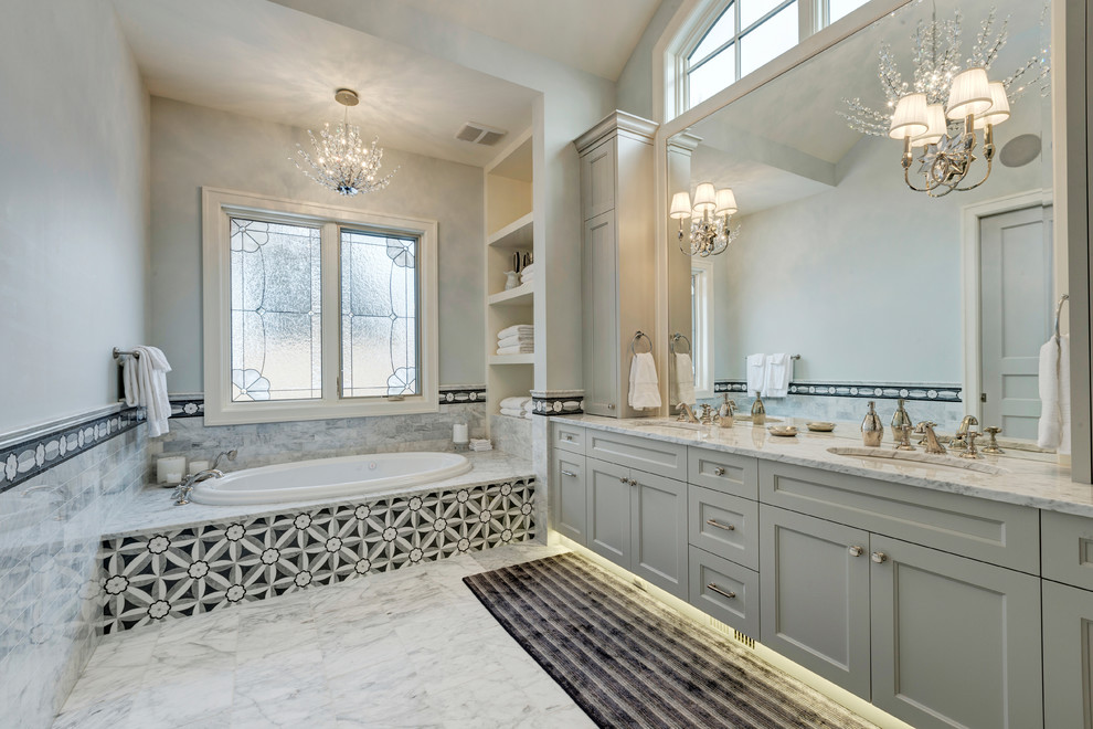 Inspiration for a large transitional master gray tile and ceramic tile slate floor drop-in bathtub remodel in Calgary with an undermount sink, recessed-panel cabinets, blue cabinets, granite countertops, a one-piece toilet and blue walls
