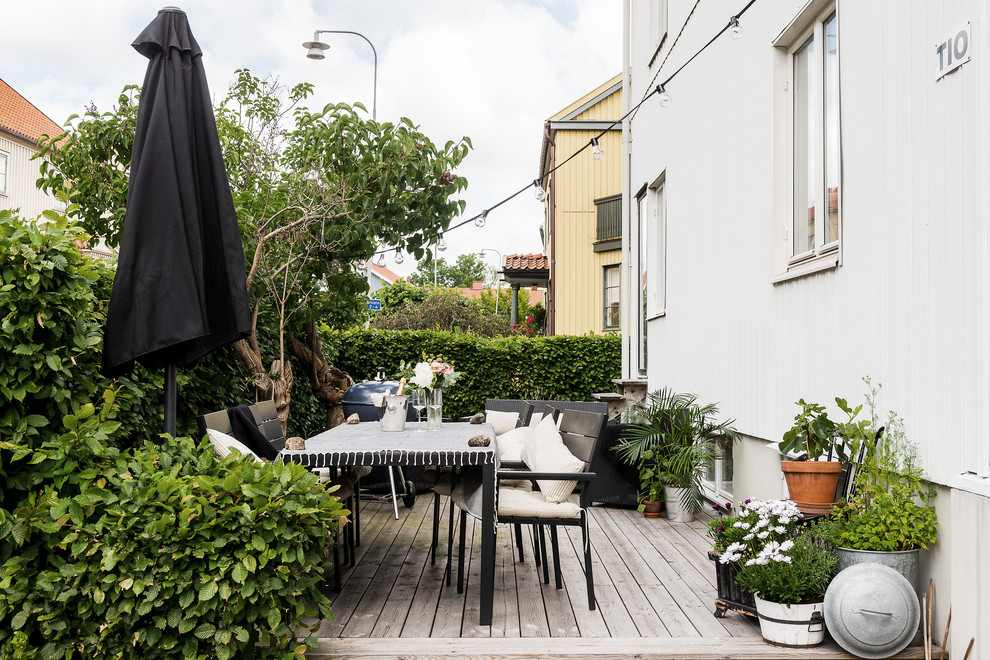 Inredning av en nordisk mellanstor uteplats framför huset, med utekrukor
