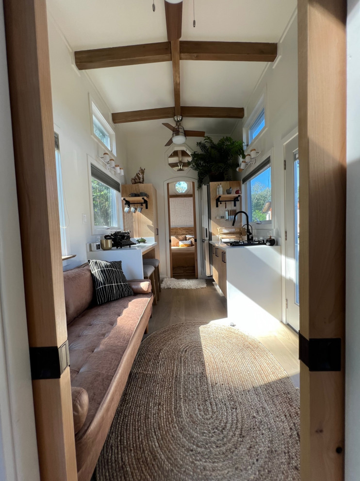 Inspiration for a small cottage light wood floor, beige floor and exposed beam entryway remodel in Hawaii with white walls and a glass front door