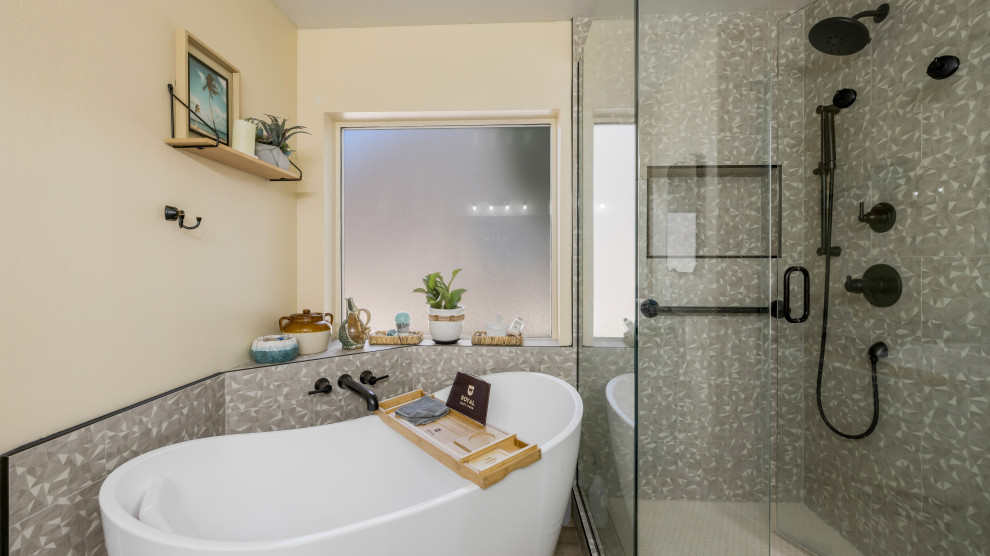 Modern inredning av ett stort en-suite badrum, med ett fristående badkar, en hörndusch, grå kakel, porslinskakel, beige väggar och dusch med gångjärnsdörr