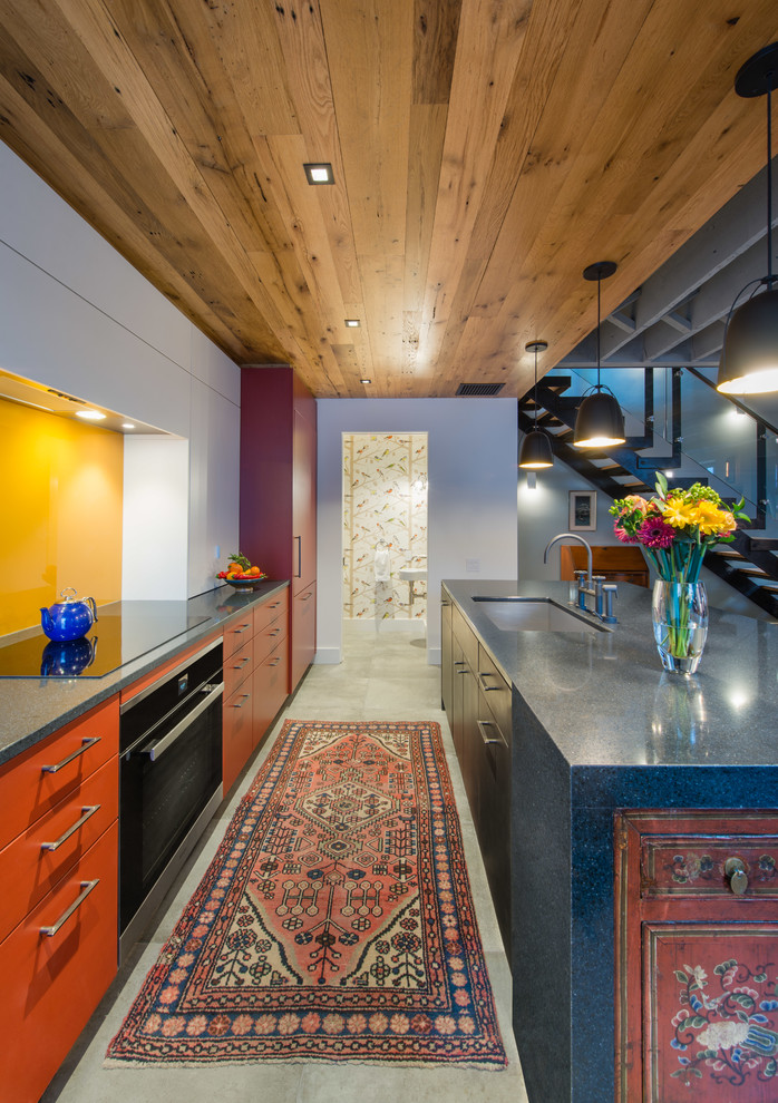 Mid-sized modern single-wall eat-in kitchen in DC Metro with an undermount sink, flat-panel cabinets, white cabinets, granite benchtops, yellow splashback, glass sheet splashback, panelled appliances, linoleum floors, with island and brown floor.