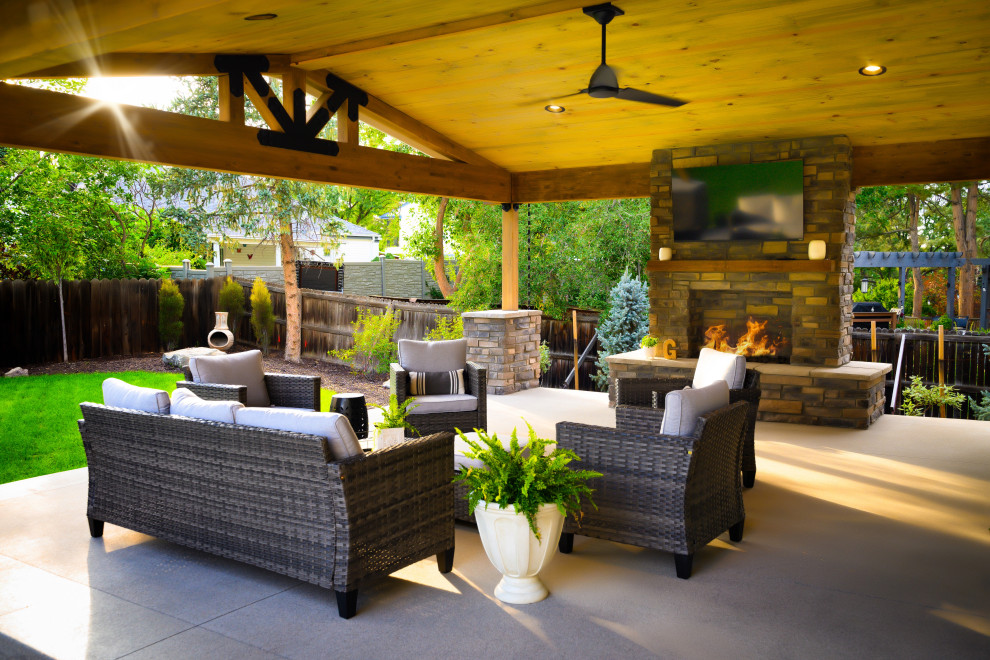 Design ideas for a traditional patio in Denver with with fireplace, concrete slab and a roof extension.