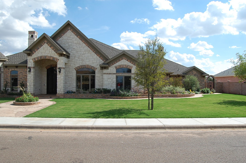 This is an example of a large traditional one-storey white exterior in Austin with stone veneer.