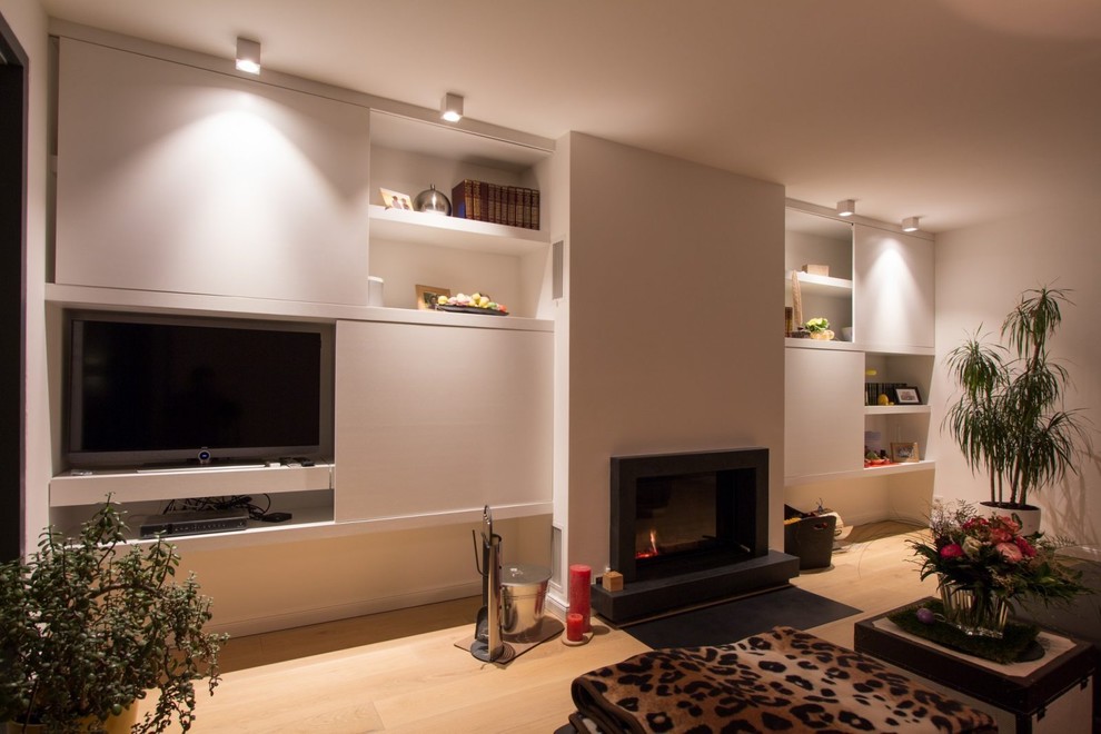 Große, Offene Moderne Bibliothek mit weißer Wandfarbe, hellem Holzboden, Kamin, verputzter Kaminumrandung, verstecktem TV und braunem Boden in Hamburg