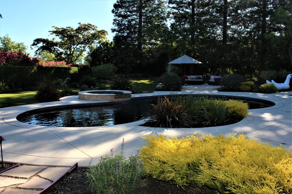 Inspiration for a large contemporary backyard custom-shaped lap pool in San Francisco with a hot tub and concrete pavers.