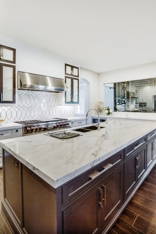 Inspiration for a huge transitional u-shaped dark wood floor eat-in kitchen remodel in Dallas with an undermount sink, shaker cabinets, beige cabinets, marble countertops, white backsplash, porcelain backsplash, stainless steel appliances and two islands