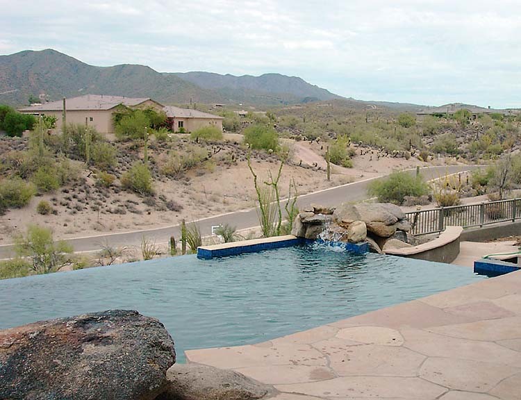 Mid-sized backyard stamped concrete and rectangular infinity hot tub photo in Phoenix
