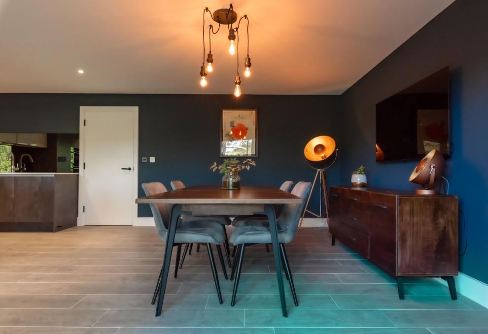 This is an example of a medium sized urban open plan dining room in Kent with blue walls, laminate floors, grey floors and feature lighting.