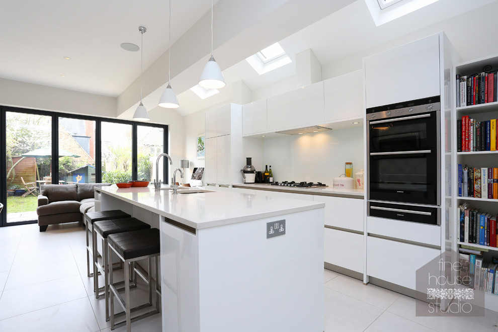 Design ideas for a large contemporary eat-in kitchen in London with an undermount sink, white cabinets, quartz benchtops, glass sheet splashback, ceramic floors and with island.