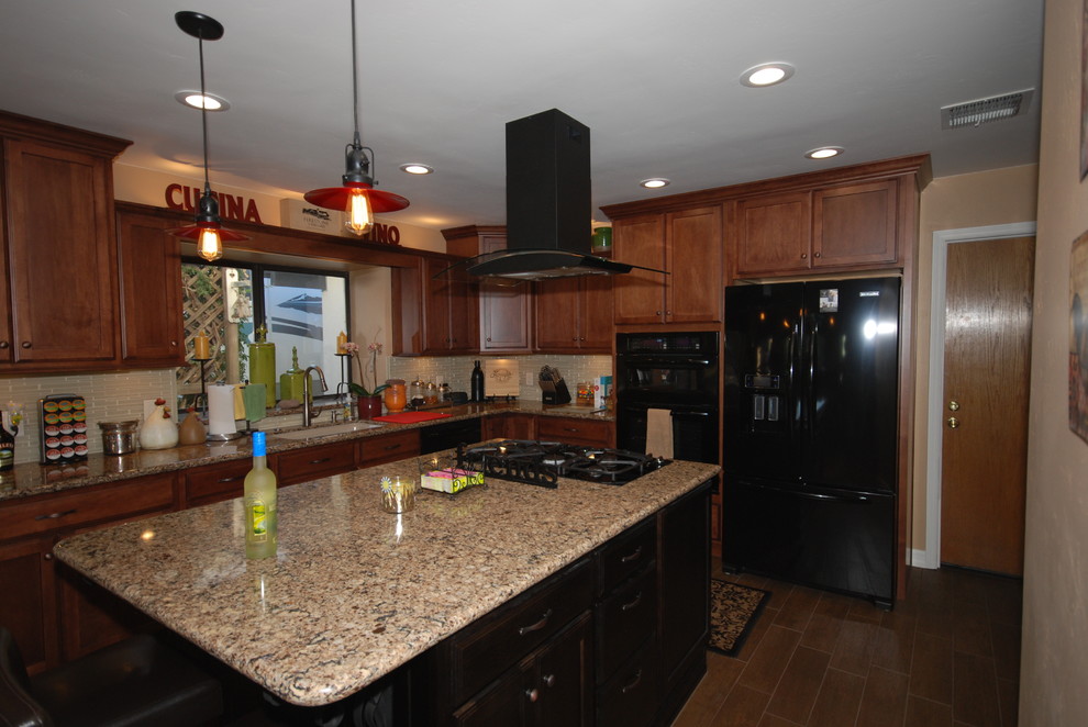 Inspiration for a timeless u-shaped eat-in kitchen remodel with an undermount sink, shaker cabinets, brown cabinets, quartz countertops, beige backsplash, glass sheet backsplash and black appliances