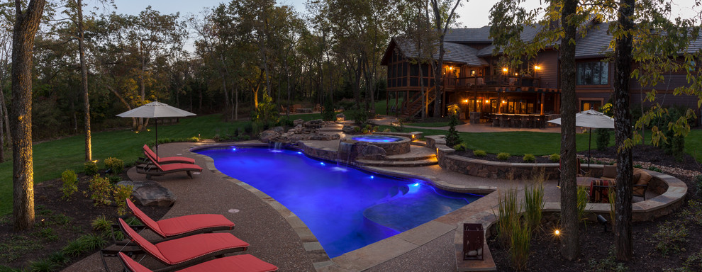 Large arts and crafts backyard custom-shaped pool in Kansas City with a hot tub and concrete slab.