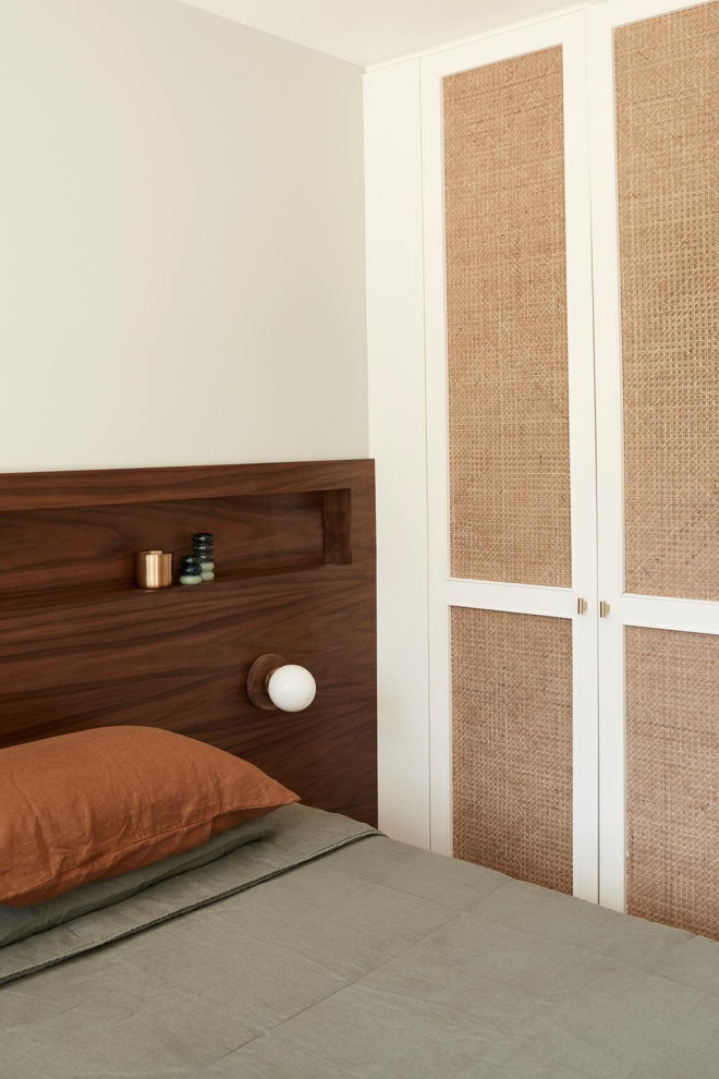This is an example of a midcentury guest bedroom in Sydney with white walls, beige floor and wood.