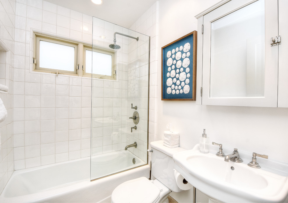 Small beach style 3/4 bathroom in Orange County with an alcove tub, a shower/bathtub combo, a two-piece toilet, white tile, ceramic tile, white walls, a pedestal sink and an open shower.