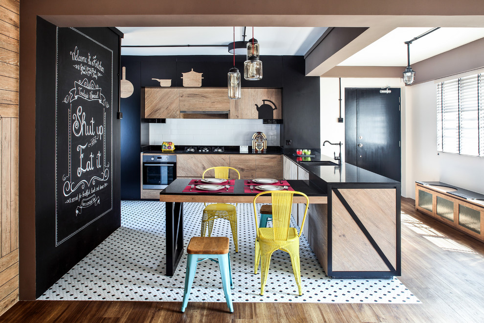 Design ideas for a contemporary l-shaped eat-in kitchen in Singapore with an undermount sink, flat-panel cabinets, light wood cabinets, white splashback, subway tile splashback, black appliances, a peninsula and black benchtop.