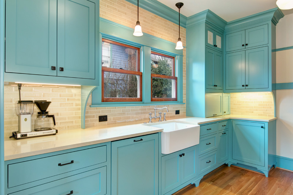 Inspiration for a large traditional galley separate kitchen in Portland with a farmhouse sink, shaker cabinets, blue cabinets, quartz benchtops, beige splashback, subway tile splashback, stainless steel appliances, light hardwood floors and no island.