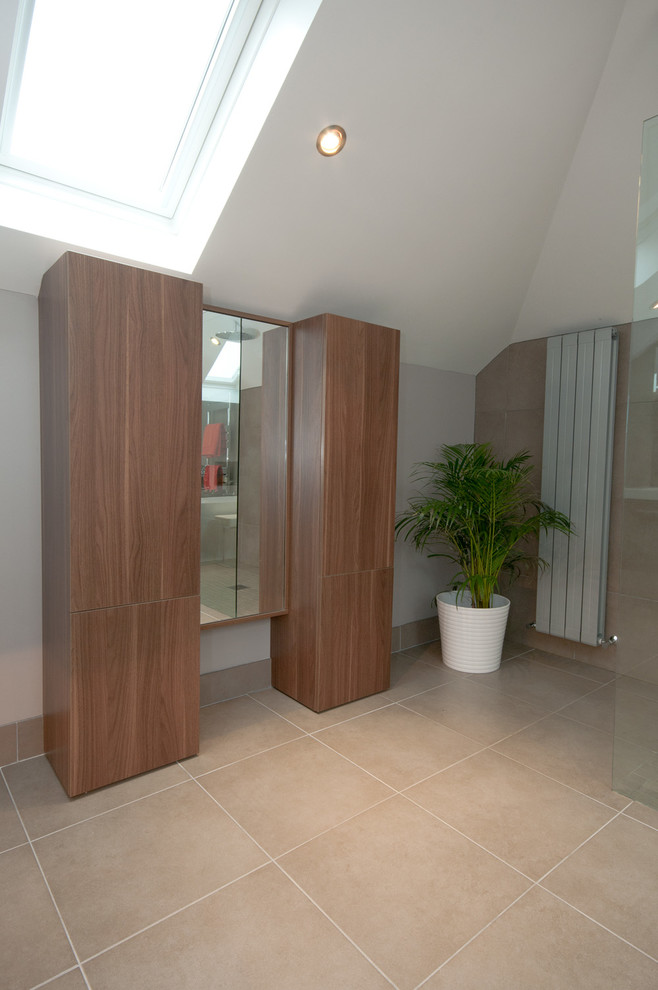Inspiration for a large contemporary master bathroom in Belfast with medium wood cabinets, a freestanding tub, an open shower, a wall-mount toilet, beige tile and porcelain floors.