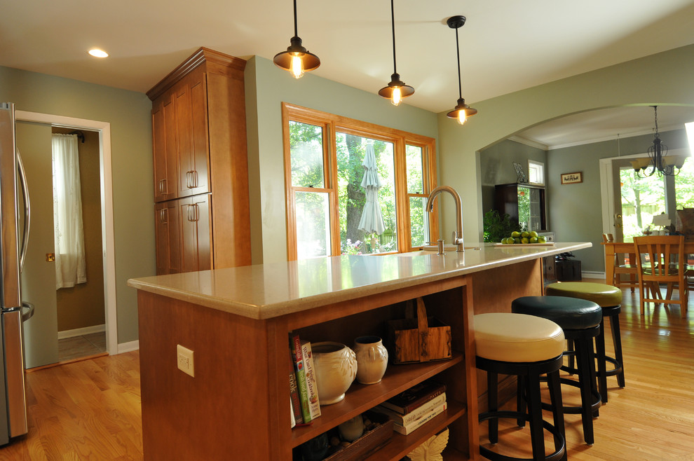 Kitchen - transitional light wood floor kitchen idea in Chicago with a farmhouse sink, medium tone wood cabinets, quartz countertops, beige backsplash, stainless steel appliances and an island
