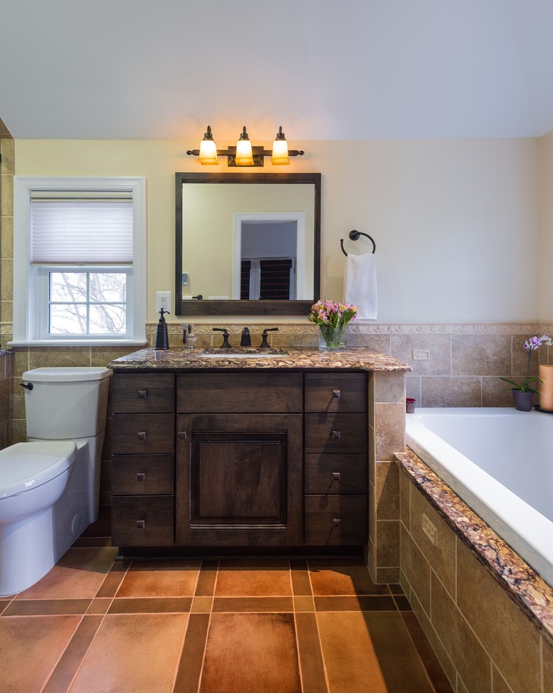 Design ideas for a large mediterranean master bathroom in DC Metro with an undermount sink, flat-panel cabinets, brown cabinets, granite benchtops, a drop-in tub, a corner shower, a two-piece toilet, beige tile, ceramic tile, beige walls and ceramic floors.