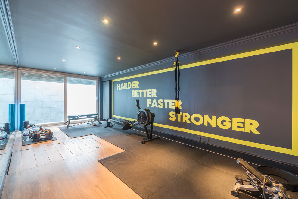Design ideas for a large contemporary multipurpose gym in London with multi-coloured walls, light hardwood floors and brown floor.