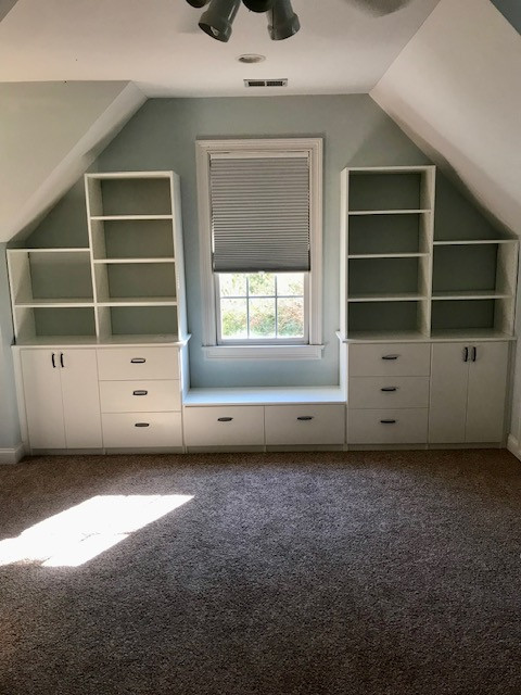 Window Seat with Slanted Ceilings Featuring Drawers, Cabinets, and Shelving