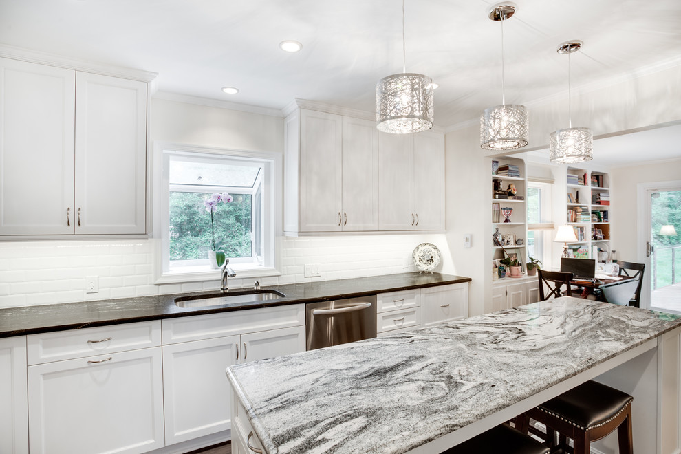 This is an example of a large transitional u-shaped kitchen in DC Metro with an undermount sink, recessed-panel cabinets, white cabinets, granite benchtops, white splashback, subway tile splashback, stainless steel appliances and with island.