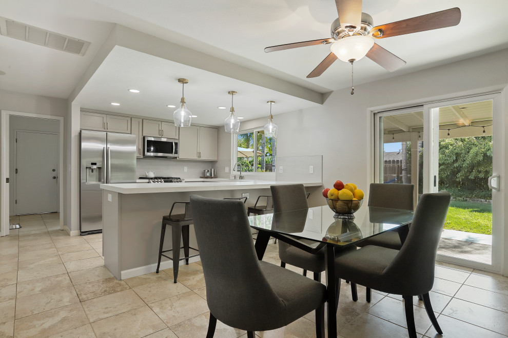 This is an example of a modern u-shaped eat-in kitchen in Sacramento with an undermount sink, beige cabinets, quartz benchtops, white splashback, porcelain splashback, stainless steel appliances, a peninsula and white benchtop.