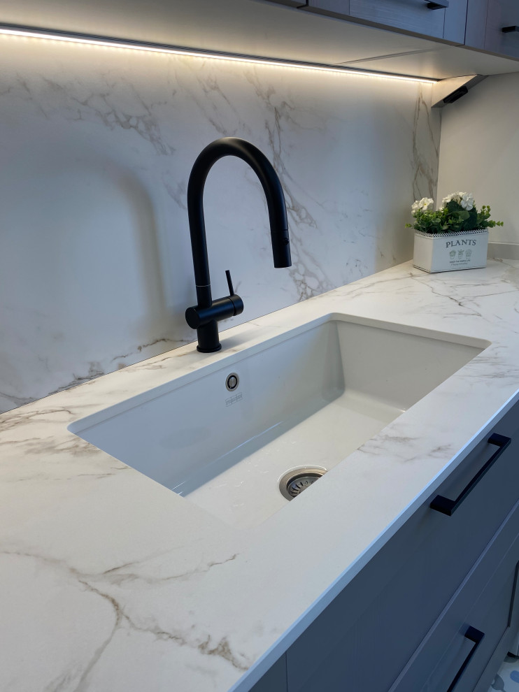 This is an example of a large transitional u-shaped separate kitchen in Other with an undermount sink, beaded inset cabinets, pink cabinets, marble benchtops, white splashback, marble splashback, coloured appliances, porcelain floors, multiple islands, multi-coloured floor and white benchtop.