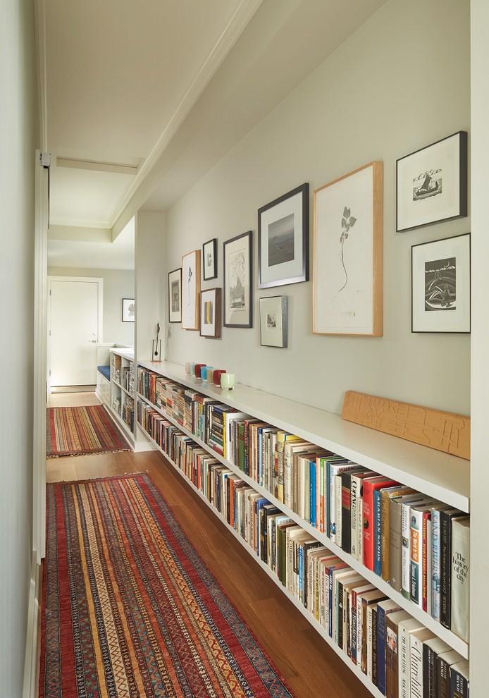 This is an example of a small transitional hallway in Seattle with white walls and medium hardwood floors.