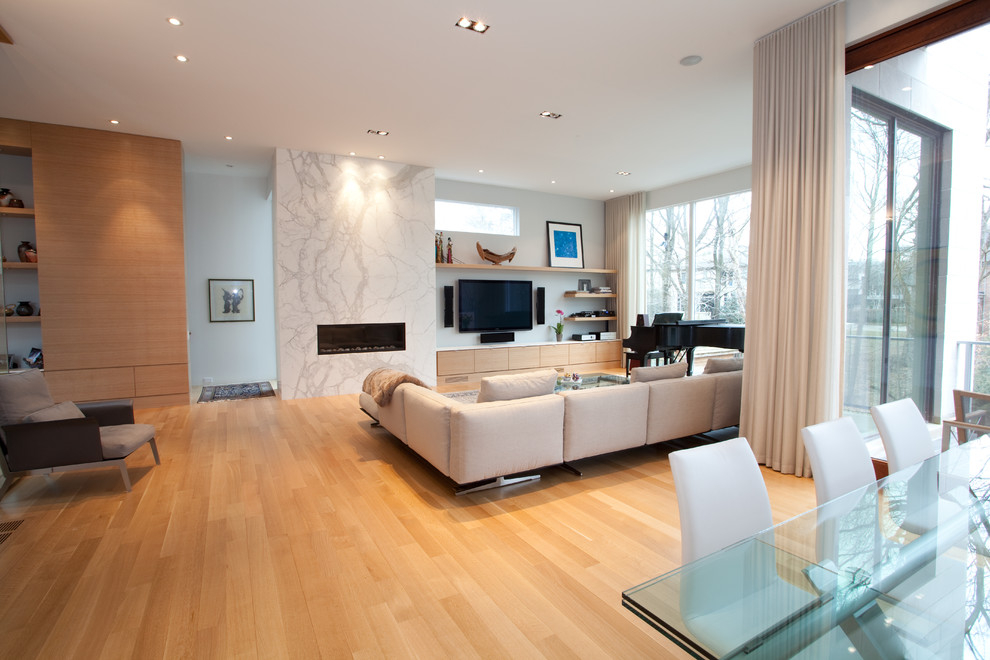 Inspiration for a mid-sized modern open concept living room in Toronto with a music area, medium hardwood floors, a ribbon fireplace and a wall-mounted tv.