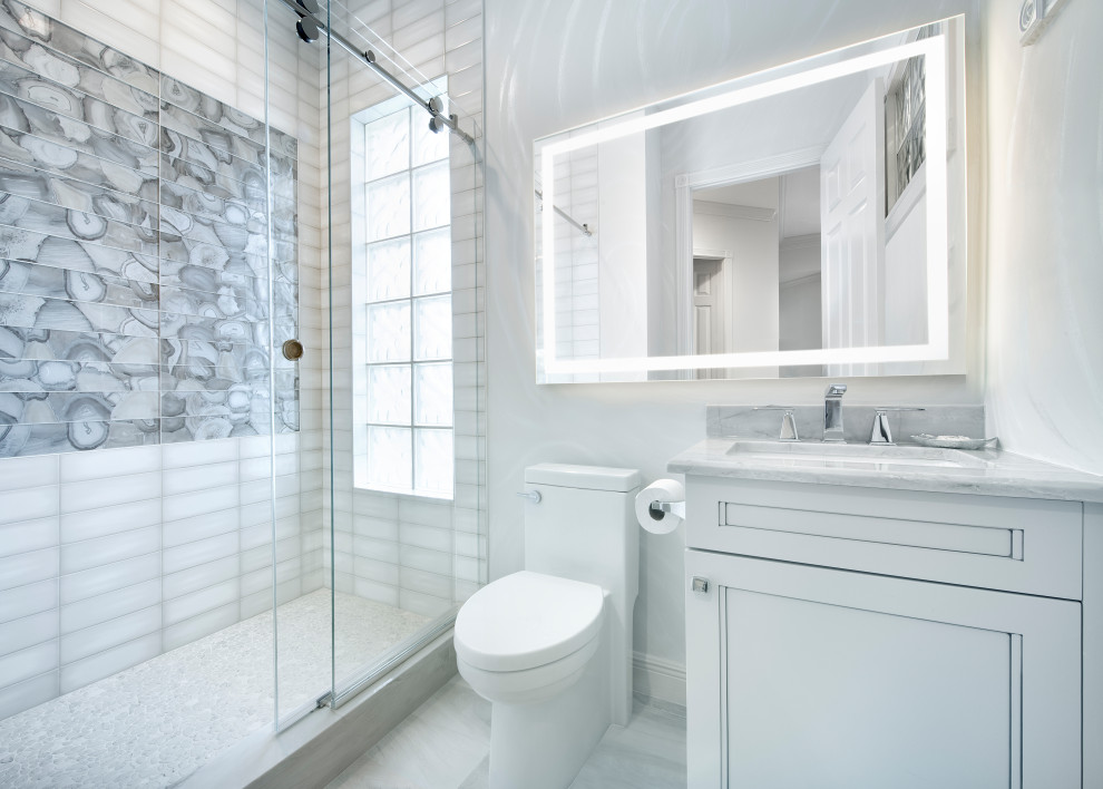This is an example of a mid-sized transitional 3/4 bathroom in Miami with recessed-panel cabinets, white cabinets, an alcove shower, a one-piece toilet, white tile, porcelain tile, white walls, ceramic floors, an undermount sink, quartzite benchtops, white floor, a sliding shower screen, white benchtops, a single vanity and a built-in vanity.
