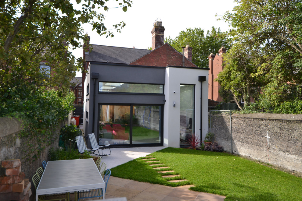 Photo of a Small modern Two Floor Render semi-detached house in Dublin With a Flat Roof and a Mixed Material Roof.